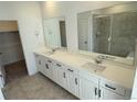 Bathroom featuring double vanity with modern fixtures, large mirrors, and a glass door shower at 3441 N Denali St, Aurora, CO 80019