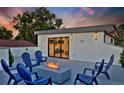 Stylish rooftop deck with fire pit, Adirondack chairs and sliding door access to the home's interior at 1374 S Vine St, Denver, CO 80210