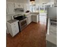 Charming kitchen with white cabinets, stainless steel appliances, and tiled countertops, creating a cozy cooking space at 4362 Denmark Ct, Denver, CO 80239