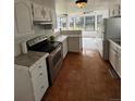 Well-lit kitchen featuring white cabinets, stainless steel appliances, and a seamless transition to the adjacent dining area at 4362 Denmark Ct, Denver, CO 80239