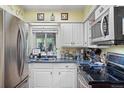 Functional kitchen featuring modern appliances, white cabinetry, and ample counter space at 8501 W 52Nd Ave, Arvada, CO 80002
