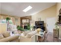 Cozy living room with a beautiful stone fireplace, skylight, and comfortable seating arrangement at 10150 E Virginia Ave # 18-302, Denver, CO 80247