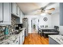 Modern kitchen with stainless steel appliances, granite countertops, hardwood floors, gray cabinets, and an adjacent dining area at 327 N 12Th Ave, Brighton, CO 80601