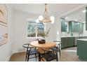 Bright dining area with modern lighting fixture, table, and green cabinets offering a welcoming and stylish space at 211 Newport St, Denver, CO 80220