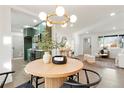 Elegant dining area featuring a modern light fixture, a round table with seating for four, and an open view to the kitchen at 211 Newport St, Denver, CO 80220