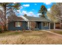 Charming single-story home featuring a blue brick facade, gray roof, and a well-maintained front yard at 211 Newport St, Denver, CO 80220