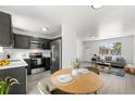 Open floor plan featuring an updated kitchen, dining area, and living room with neutral colors and natural light at 5993 Oneida St, Commerce City, CO 80022