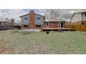 Brick house boasts a backyard with a small deck and a patch of green space at 4410 S Estes St, Littleton, CO 80123