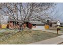 Charming home with a two-car garage, brick facade, and mature tree at 4410 S Estes St, Littleton, CO 80123