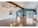 Bright living room featuring wood-look floors, vaulted ceiling, and a cozy wood-burning stove at 12189 N Boot Hill Dr, Parker, CO 80138