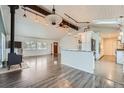 Open-concept living room with wood-look floors, white ceiling and beams, and view of the kitchen at 12189 N Boot Hill Dr, Parker, CO 80138