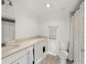 Well-lit bathroom featuring a white vanity, toilet, neutral colored flooring, and a shower with a patterned shower curtain at 4899 S Dudley St # 3, Littleton, CO 80123