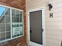 Welcoming front entrance with brick accents, a window with blinds, and a stylish light fixture at 13782 E Lehigh Ave # H, Aurora, CO 80014