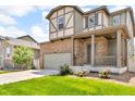 Inviting two-story home with a stone and siding facade, a two-car garage, and a well-maintained lawn with flowerbeds at 6591 N Ceylon St, Denver, CO 80249