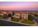 Two story home with landscaped yard and neighborhood views at sunset at 5562 Rim View Pl, Parker, CO 80134