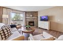 Comfortable living room with a stone fireplace, sliding glass doors to deck, and neutral-toned furniture at 8225 Fairmount Dr # 106, Denver, CO 80247