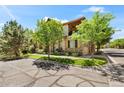 Charming townhome with stone accents, two-car garage, and balcony providing an inviting and appealing exterior at 10064 Bluffmont Ct, Lone Tree, CO 80124