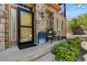 Inviting front porch with stone accents, space for seating, and lovely landscaping adding to the curb appeal at 10064 Bluffmont Ct, Lone Tree, CO 80124