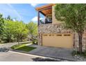 Attached two-car garage with balcony above on a townhome featuring low-maintenance landscaping and easy access at 10064 Bluffmont Ct, Lone Tree, CO 80124