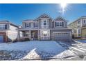 Two-story gray home with a welcoming front porch and attached two-car garage at 15972 E Tall Timber Ln, Parker, CO 80134