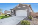 Gray exterior home with white garage door, landscaping, and a concrete driveway at 1152 Payton Ave, Fort Lupton, CO 80621