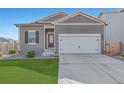 Gray exterior ranch home with white garage door, landscaping, and a short driveway at 1152 Payton Ave, Fort Lupton, CO 80621