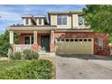 Charming two-story home featuring a brick facade, a cozy front porch, and a spacious two-car garage at 3109 S Jebel Way, Aurora, CO 80013