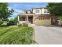 Charming two-story home featuring a brick facade, a cozy front porch, and a spacious two-car garage at 3109 S Jebel Way, Aurora, CO 80013