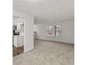 Bright living room featuring neutral carpet and ample natural light through the large windows at 1643 S Fairplay St, Aurora, CO 80012