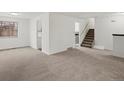 Bright living room featuring neutral carpeting, staircase, and lots of natural light at 1643 S Fairplay St, Aurora, CO 80012