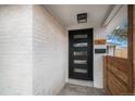 Home exterior featuring a modern black front door with glass panes and a white brick facade at 1362 Wolff St, Denver, CO 80204