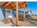 Charming entrance featuring a covered porch, wood steps, white trim, and a welcoming ambiance at 6365 W Coal Mine Ave, Littleton, CO 80123