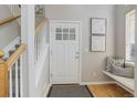 Welcoming entryway with hardwood floors, bright natural light, a staircase, and cozy bench seating at 9612 W Indore Dr, Littleton, CO 80128