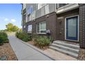 Well-maintained entryway with walkway, steps and a blue door at 1615 Harlan St # 2, Lakewood, CO 80214