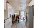 Open concept living room adjacent to the kitchen with stainless steel refrigerator at 625 S Clinton St # 6B, Denver, CO 80247