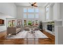 Bright living room boasts hardwood floors, a fireplace, and a wall of windows at 14325 N Santa Fe St, Broomfield, CO 80023