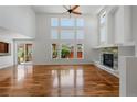 Bright living room boasts hardwood floors, a fireplace, and a wall of windows at 14325 N Santa Fe St, Broomfield, CO 80023