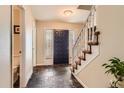Welcoming foyer with slate flooring and a staircase with carpet runners at 7573 S Saulsbury Ct, Littleton, CO 80128