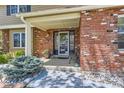Inviting covered front porch with brick detail and decorative plants at 7573 S Saulsbury Ct, Littleton, CO 80128