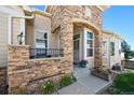 Welcoming front entrance with a stone pillar and an archway with a colorful pot of flowers at 3742 E 127Th Ln, Thornton, CO 80241