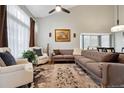 Bright living room with vaulted ceilings, a large sectional sofa, and a decorative rug at 2529 S Truckee Way, Aurora, CO 80013