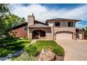 Charming home exterior with brick accents, well-maintained lawn, mature landscaping and a two car garage at 559 E 2Nd Ave, Castle Rock, CO 80108