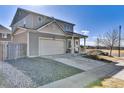 Gray two-story home features a two-car garage and a cozy covered front porch at 13464 E 107Th Ave, Commerce City, CO 80022