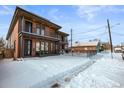 Charming home displaying a brick facade, balcony, and snow-covered front yard with metal fencing at 1864 W 41St Ave, Denver, CO 80211