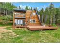 Charming A-frame home with a spacious wooden deck and lush greenery at 509 Paiute Rd, Evergreen, CO 80439