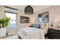 Bedroom with a queen bed, white and blue decor, and wood-paneled wall at 11053 Snowdon St, Parker, CO 80134
