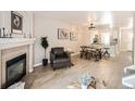 Open-concept living and dining area with light hardwood floors and a cozy fireplace at 8264 S Fillmore Way, Centennial, CO 80122