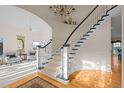 Grand curved staircase with white railings and hardwood floors at 7172 Waterford Ct, Niwot, CO 80503