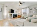 Open living room features a modern fireplace, a comfy white sectional and wood flooring at 3111 Youngheart Way, Castle Rock, CO 80109