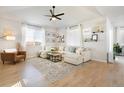 Bright living room features a comfy white sectional, modern decor, and beautiful natural light at 3111 Youngheart Way, Castle Rock, CO 80109